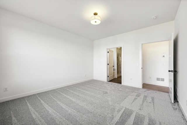 unfurnished bedroom featuring connected bathroom and carpet flooring