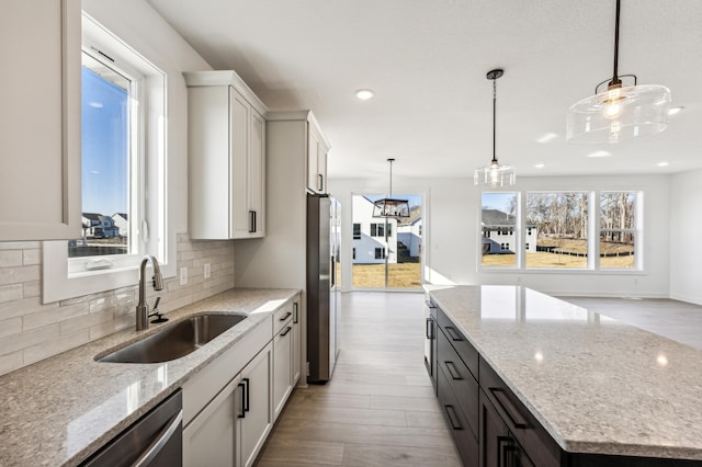 kitchen featuring sink, appliances with stainless steel finishes, hanging light fixtures, and a kitchen island