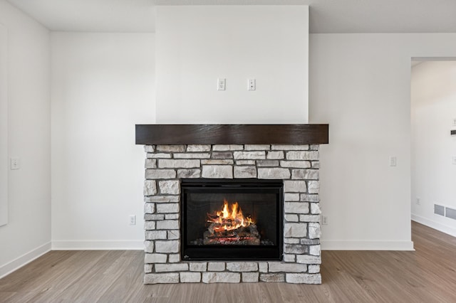 details with hardwood / wood-style flooring and a fireplace