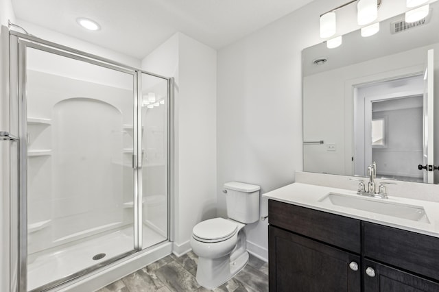 bathroom with vanity, toilet, wood-type flooring, and an enclosed shower