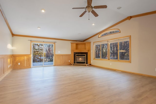 unfurnished living room with crown molding, light wood-type flooring, and vaulted ceiling