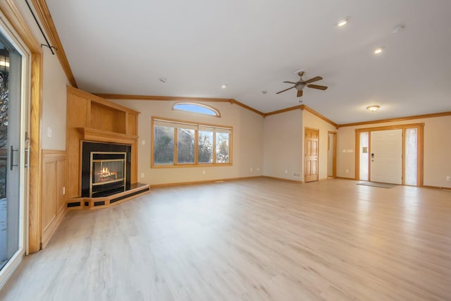 unfurnished living room featuring lofted ceiling, crown molding, light wood-type flooring, and ceiling fan