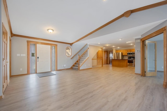 entrance foyer featuring lofted ceiling, ornamental molding, and light wood-type flooring