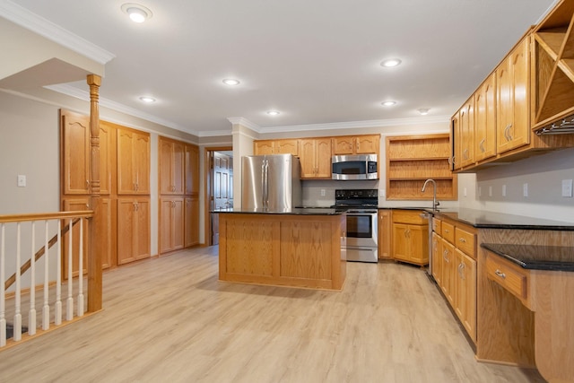 kitchen with a kitchen island, light hardwood / wood-style flooring, ornamental molding, sink, and appliances with stainless steel finishes