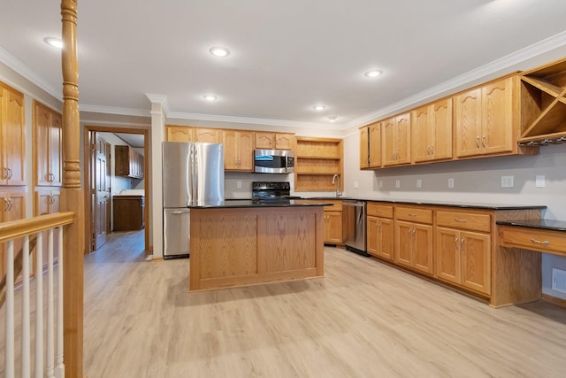 kitchen featuring a kitchen island, sink, crown molding, light wood-type flooring, and appliances with stainless steel finishes