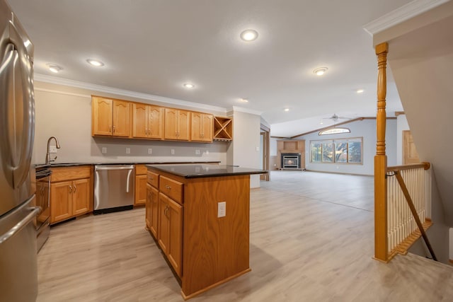 kitchen featuring a kitchen island, vaulted ceiling, sink, light hardwood / wood-style floors, and stainless steel appliances