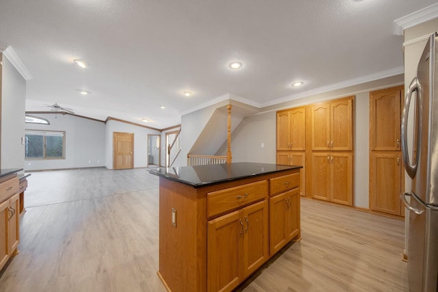 kitchen with ornamental molding, stainless steel fridge, a center island, and light wood-type flooring