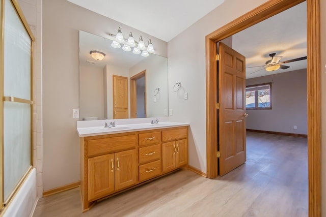 bathroom with vanity, ceiling fan, hardwood / wood-style flooring, and shower / bath combination with glass door