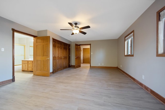 unfurnished bedroom featuring a closet, ceiling fan, ensuite bathroom, and light hardwood / wood-style floors