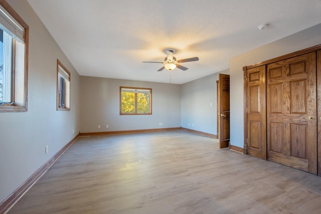 unfurnished bedroom featuring ceiling fan, a textured ceiling, and light hardwood / wood-style floors