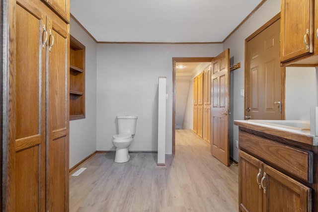 bathroom with toilet, ornamental molding, hardwood / wood-style flooring, and vanity