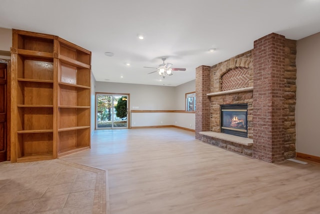 unfurnished living room with light hardwood / wood-style floors, a fireplace, and ceiling fan