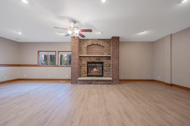 unfurnished living room with light hardwood / wood-style flooring, a fireplace, and ceiling fan