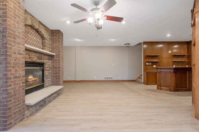 unfurnished living room featuring light hardwood / wood-style floors, a fireplace, and ceiling fan