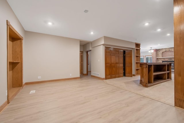 unfurnished living room featuring light hardwood / wood-style flooring and ceiling fan