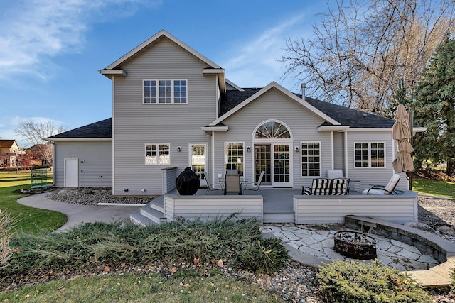 back of house featuring a deck and an outdoor fire pit