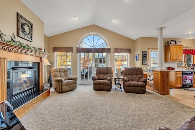 living room with a healthy amount of sunlight, light carpet, and decorative columns