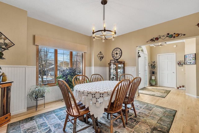 dining space with hardwood / wood-style floors, a notable chandelier, and a textured ceiling