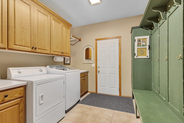 washroom featuring cabinets, independent washer and dryer, and light tile patterned floors