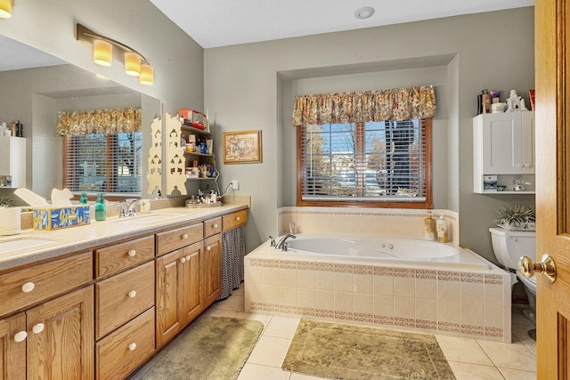 bathroom featuring tile patterned flooring, vanity, a relaxing tiled tub, and toilet