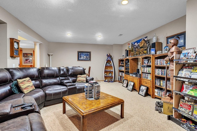 living room featuring ornate columns, a textured ceiling, and carpet floors