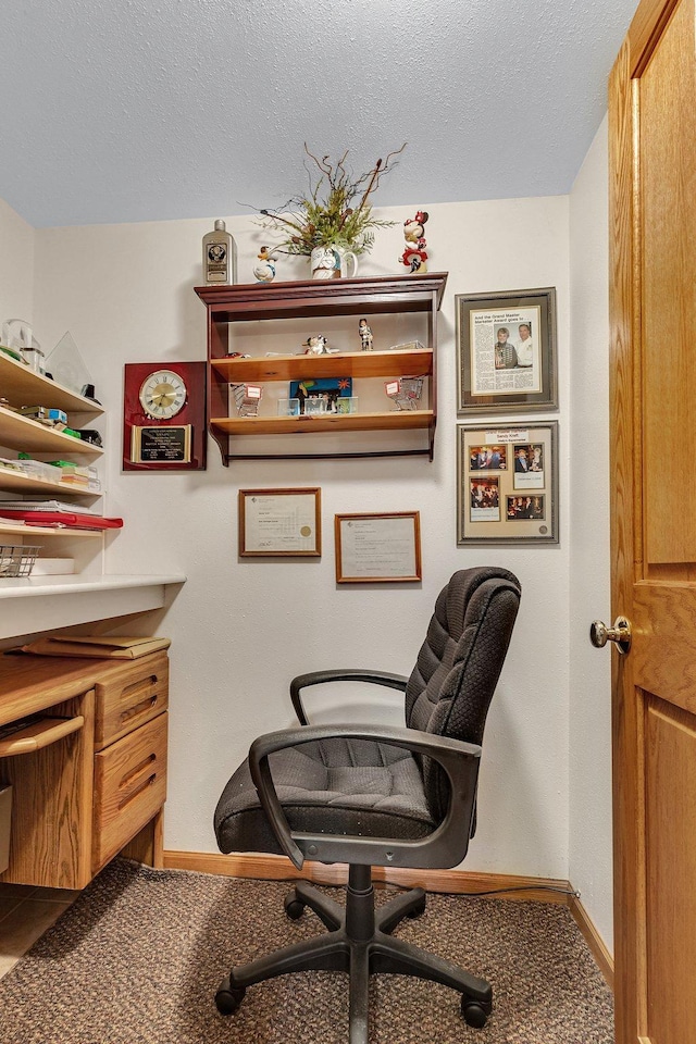 carpeted home office with a textured ceiling