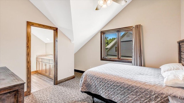 bedroom featuring lofted ceiling, ceiling fan, baseboards, and ensuite bathroom