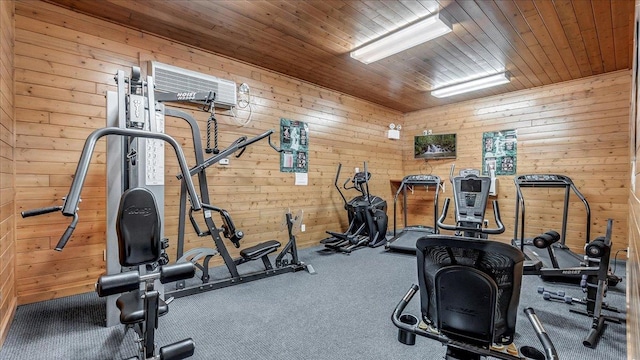 exercise area featuring carpet floors, wood walls, and wooden ceiling