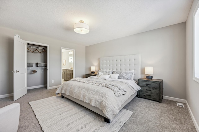 bedroom featuring visible vents, light carpet, ensuite bathroom, a closet, and baseboards