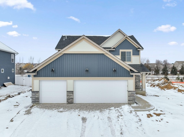 view of front of home with a garage, stone siding, fence, and a shingled roof