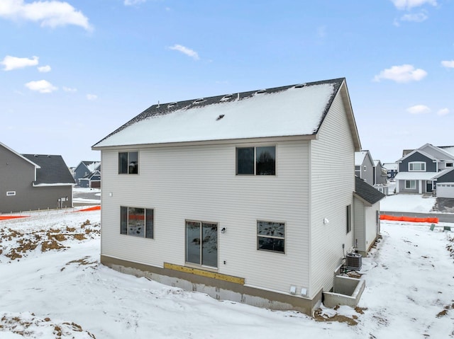 snow covered back of property with cooling unit