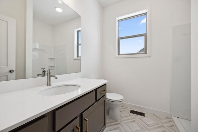 bathroom featuring a wealth of natural light, visible vents, toilet, and vanity