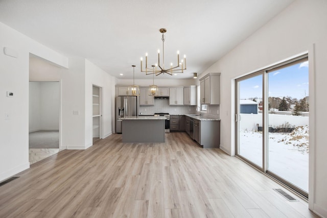 kitchen with visible vents, gray cabinetry, a notable chandelier, stainless steel appliances, and a sink