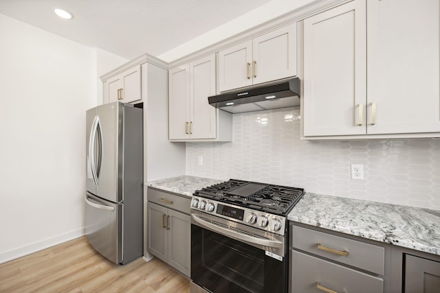 kitchen with backsplash, under cabinet range hood, gray cabinets, appliances with stainless steel finishes, and light wood-style floors