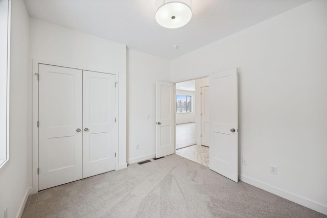 unfurnished bedroom featuring a closet, baseboards, carpet, and visible vents