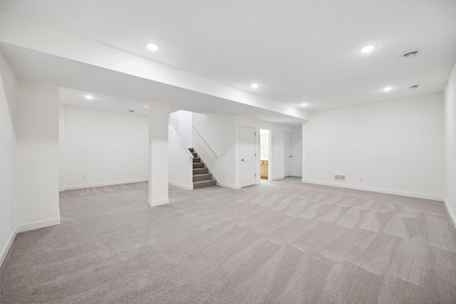 finished below grade area with recessed lighting, stairway, light colored carpet, and visible vents