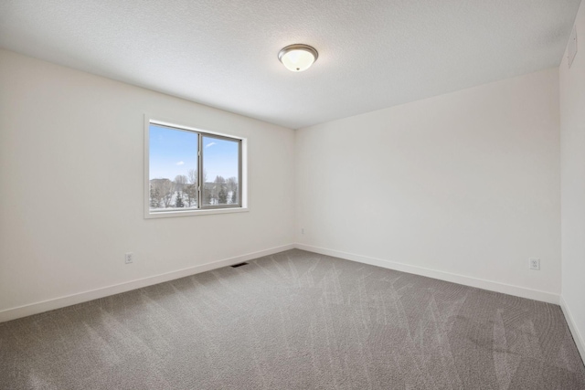 empty room featuring carpet flooring, visible vents, and baseboards