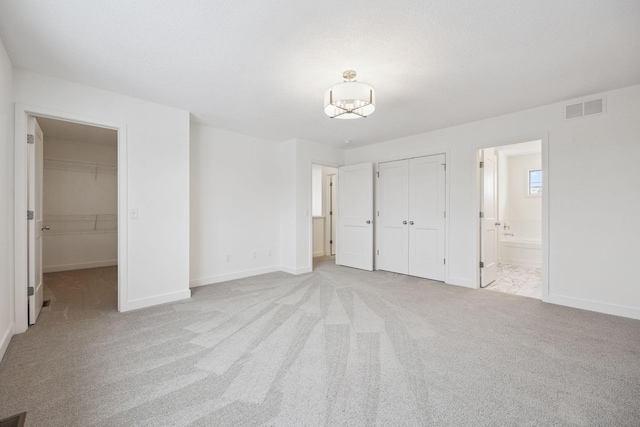 unfurnished bedroom featuring visible vents, baseboards, carpet, and a closet