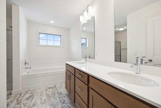 full bathroom with a garden tub, double vanity, marble finish floor, and a sink