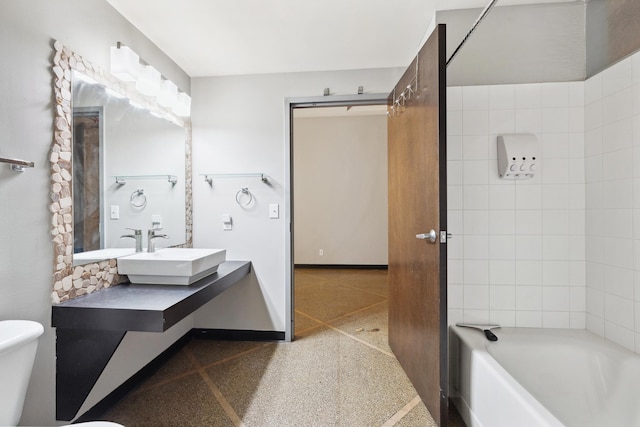 bathroom with toilet, a tub to relax in, and vanity