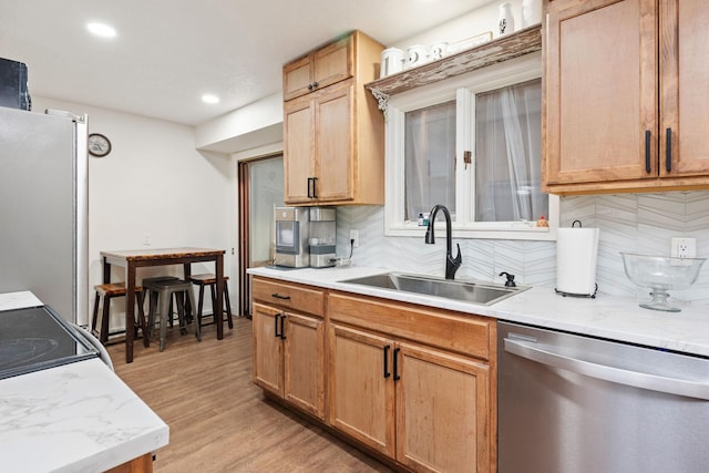 kitchen featuring backsplash, sink, light wood-type flooring, stainless steel dishwasher, and white fridge