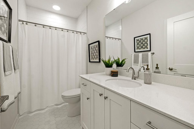 bathroom with tile patterned flooring, vanity, and toilet