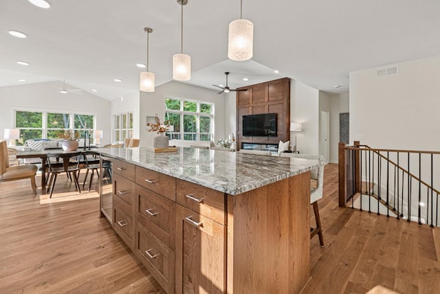 kitchen featuring a kitchen island, light wood-type flooring, and a wealth of natural light