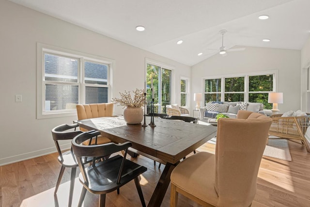 dining room featuring light hardwood / wood-style floors, vaulted ceiling, plenty of natural light, and ceiling fan