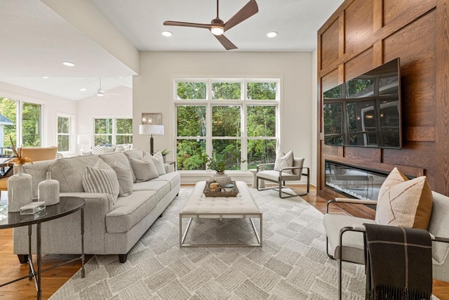 living room with a healthy amount of sunlight, light hardwood / wood-style floors, and vaulted ceiling