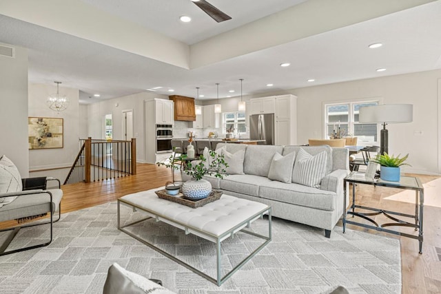 living room with a notable chandelier and light wood-type flooring