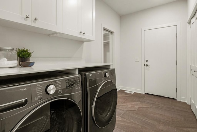 laundry room with washer and dryer, dark hardwood / wood-style flooring, and cabinets