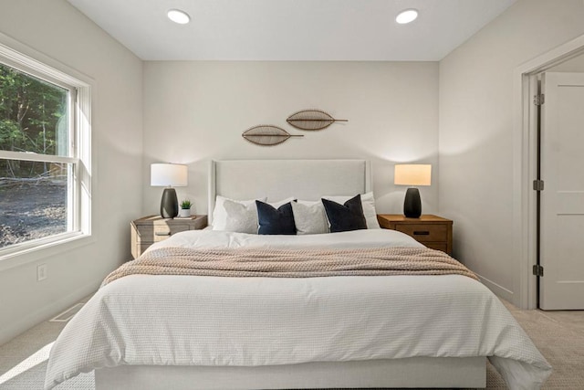 bedroom featuring light carpet and multiple windows