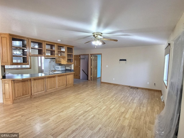 kitchen featuring ceiling fan, white appliances, kitchen peninsula, and light hardwood / wood-style flooring