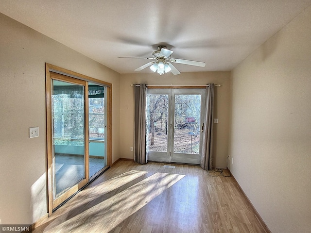 unfurnished room with light hardwood / wood-style floors, plenty of natural light, and ceiling fan